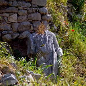 Mur en pierres devancé par une statue sans tête en pierre au milieu des plantes - Grèce  - collection de photos clin d'oeil, catégorie rues